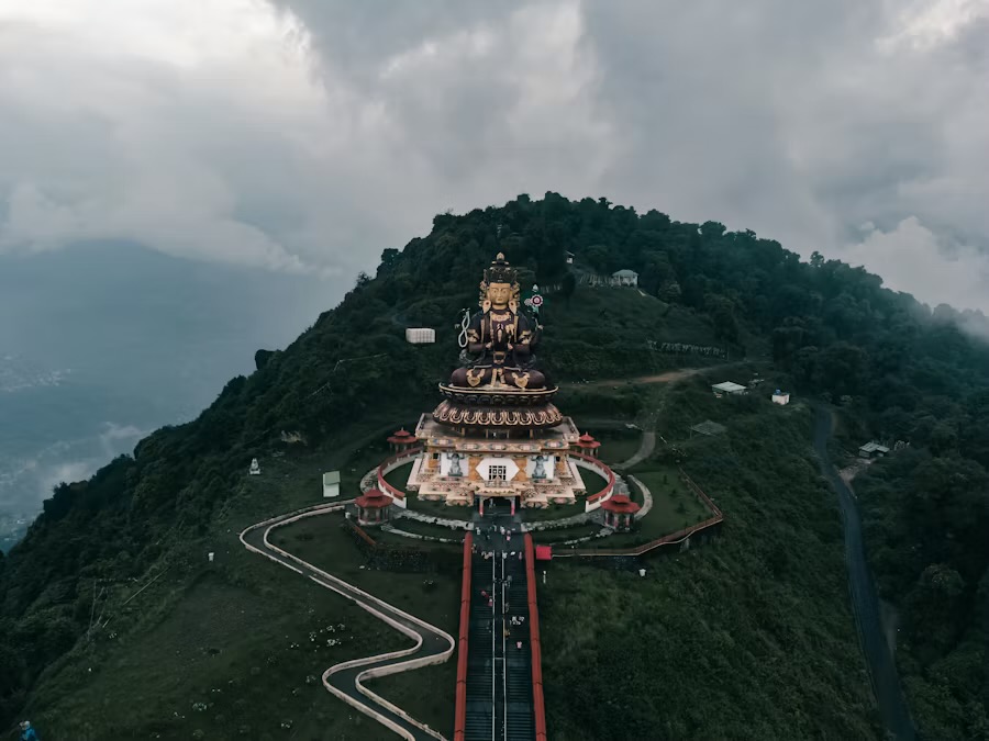 Aerial view of the Chenrezig statue and its long staircase on a forested hilltop above Pelling