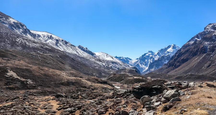 A high, bare valley in North Sikkim under snow peaks and a clear sky
