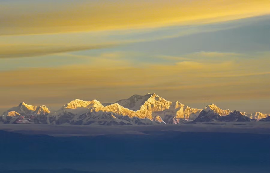The Khangchendzonga range catching sunrise light above a sea of cloud